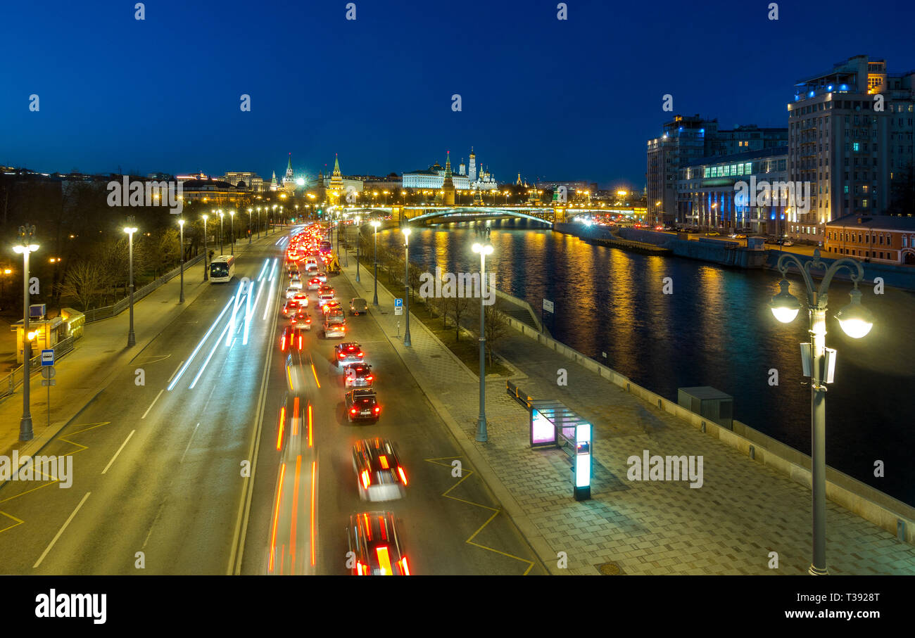Il traffico automobilistico sul terrapieno Prechistenskaya. Vista serale del fiume di Mosca, Bolshoy Kamenny Bridge e il Cremlino. Foto Stock