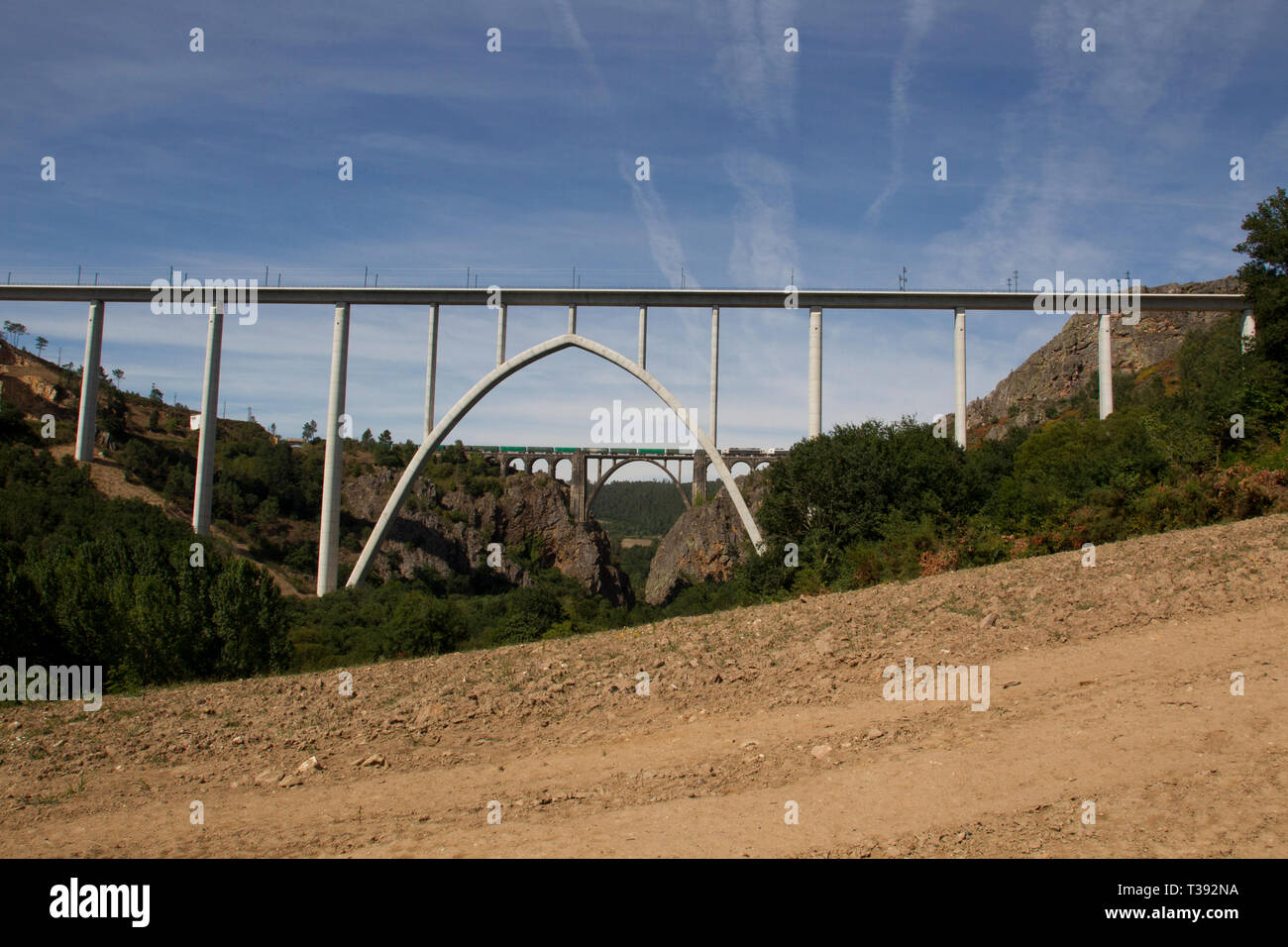 Contenitore treno merci attraversando arch ponte ferroviario attraverso Ulla river in Pontevedra, Spagna Foto Stock
