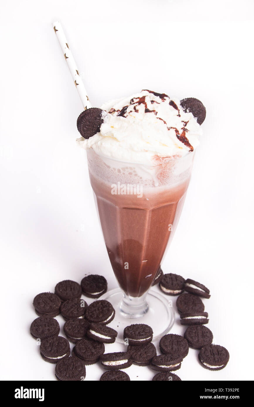 Frullato al cioccolato con pezzetti di cioccolato e i cookie sul top, isolato su bianco Foto Stock
