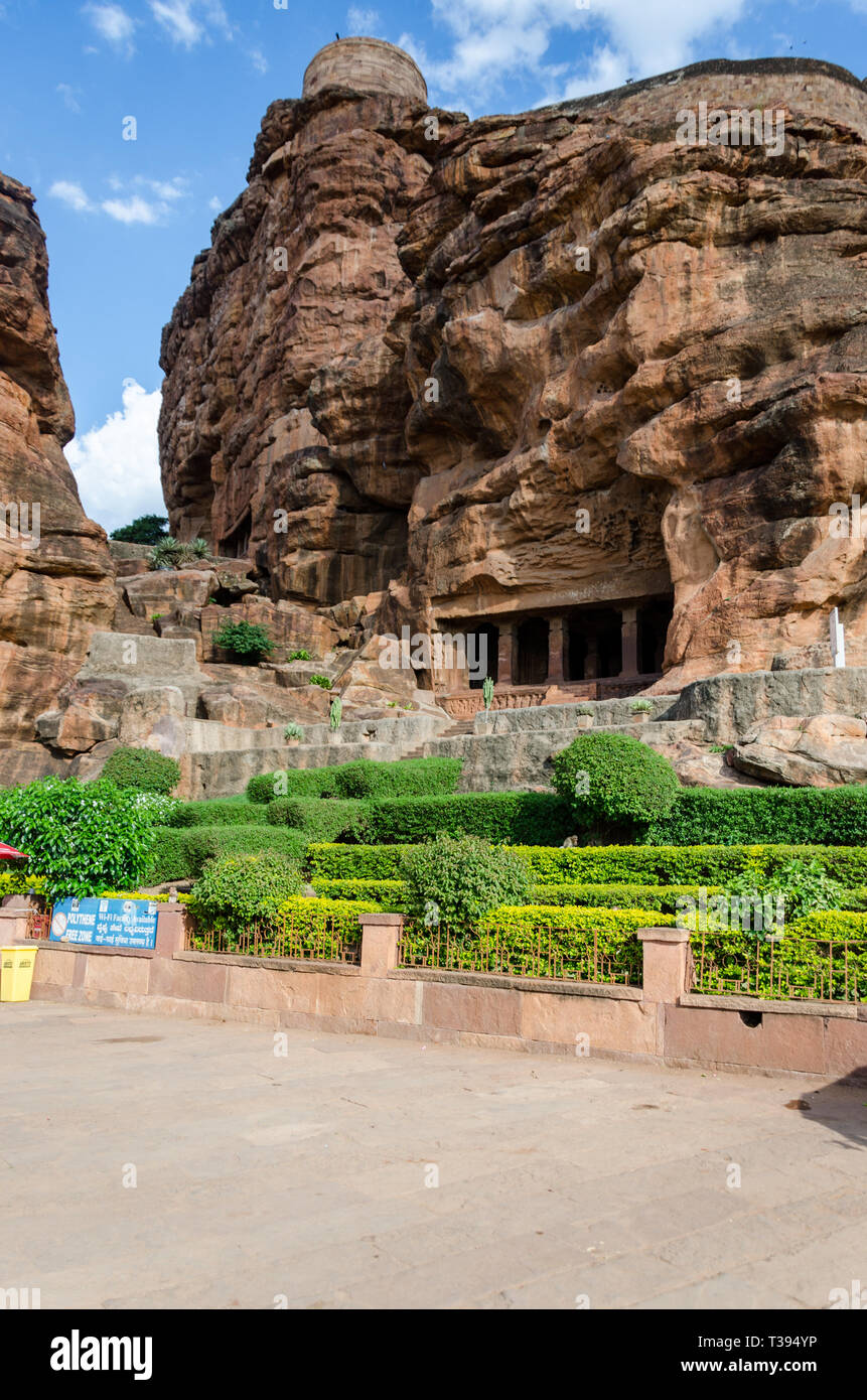 Bella Grotta Badami templi scolpiti nella pietra arenaria rossa roccia con un forte su di esso. Foto Stock