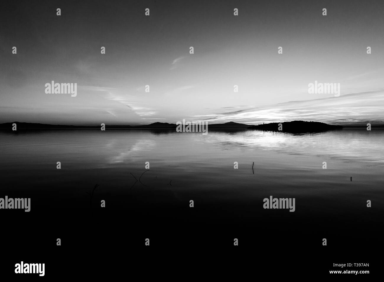 Erfectly simmetrico, splendida vista del lago Trasimeno (Umbria, Italia) al tramonto, con forme di cloud del cielo Foto Stock