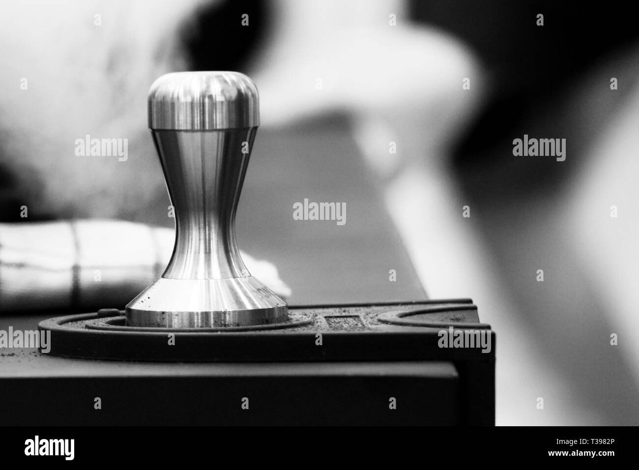 Barista che lavora in un negozio di caffè, Close up del barista preme il caffè macinato usando antimanomissione, Barista fare il caffè Portafilter Concept Foto Stock