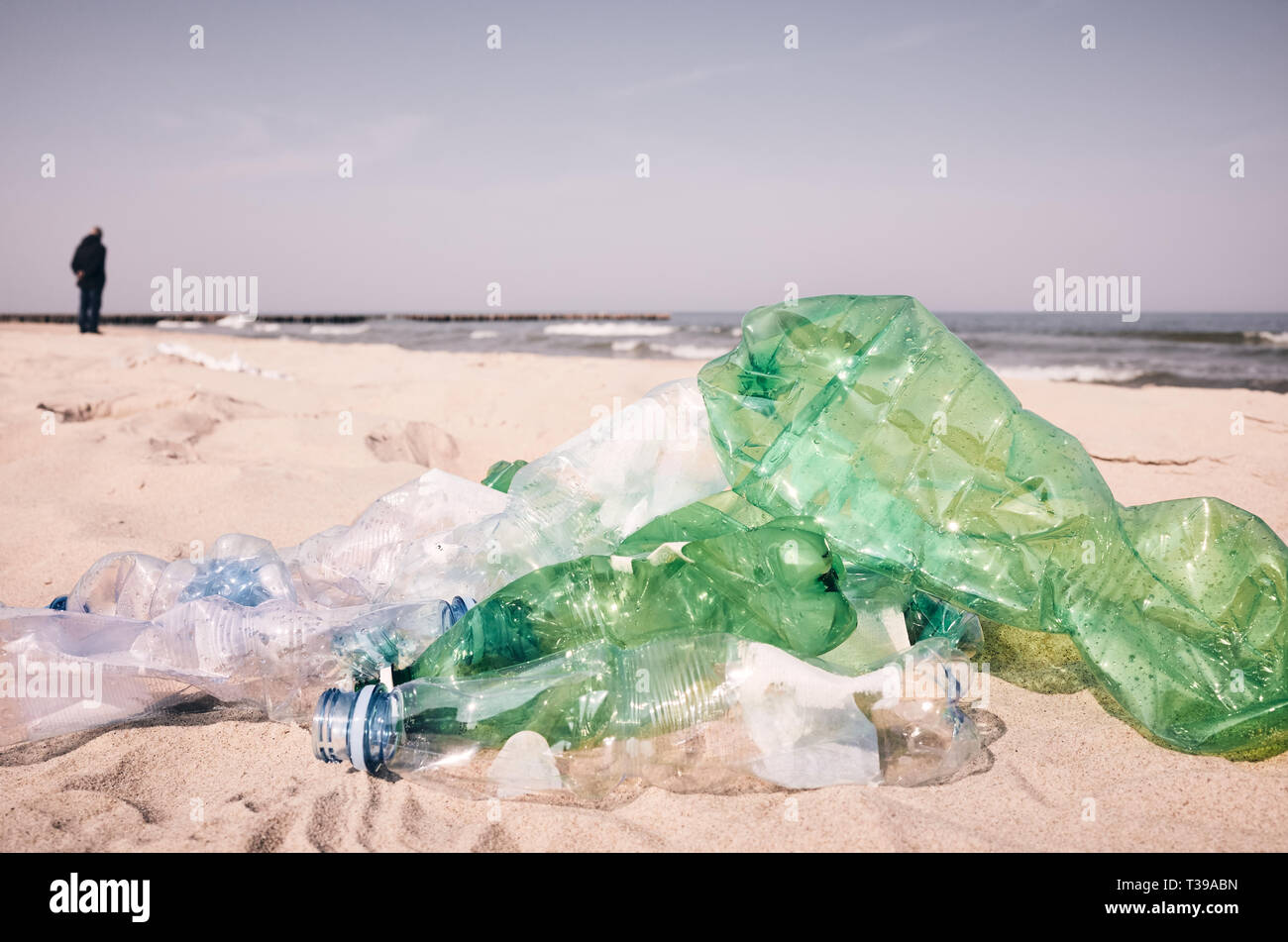 Bottiglie di plastica usate a sinistra su una spiaggia da turisti, il fuoco selettivo, tonificazione del colore applicato. Foto Stock