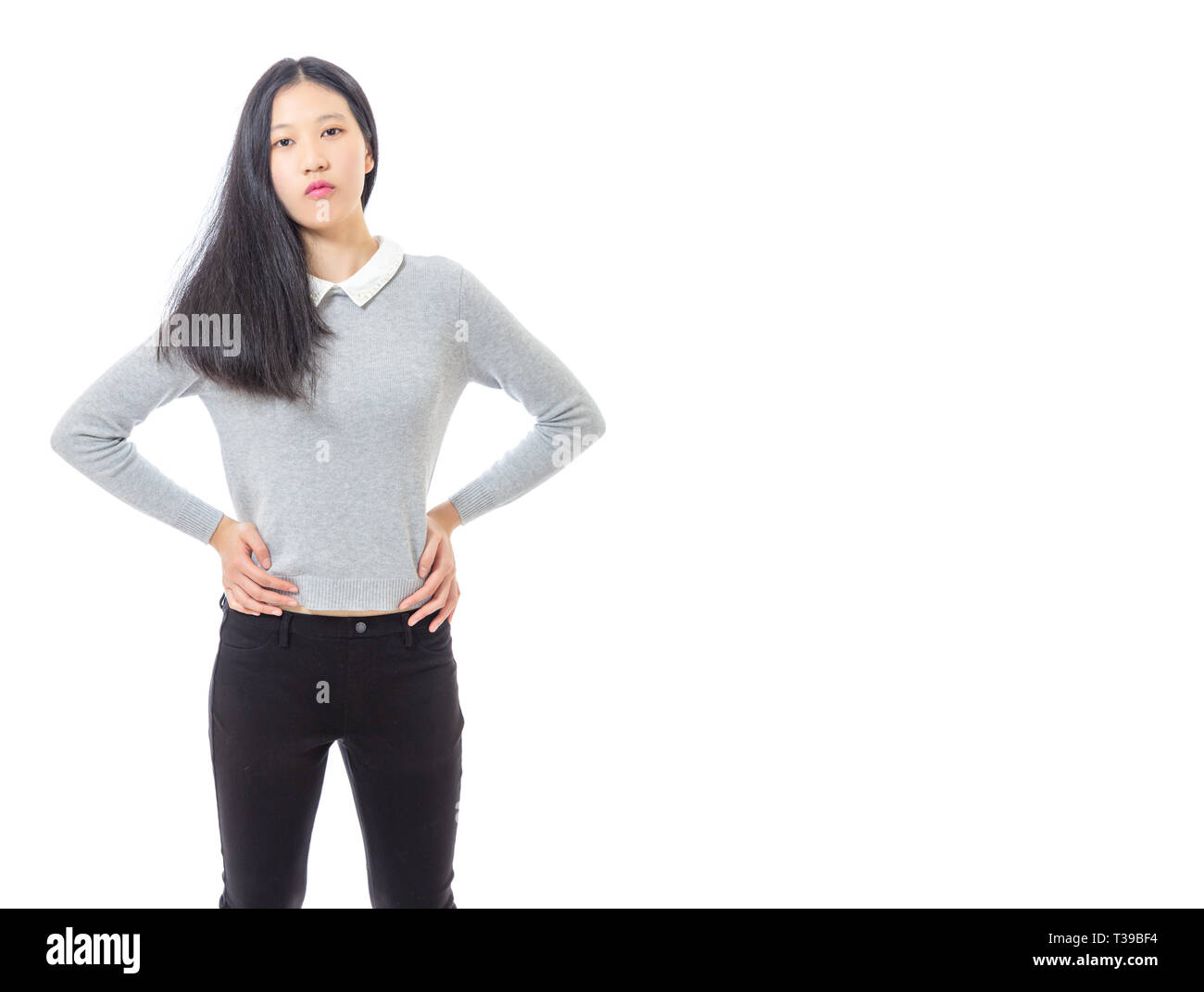 Teenage Asian high school girl le mani sui fianchi, tre quarti con spazio di copia Foto Stock