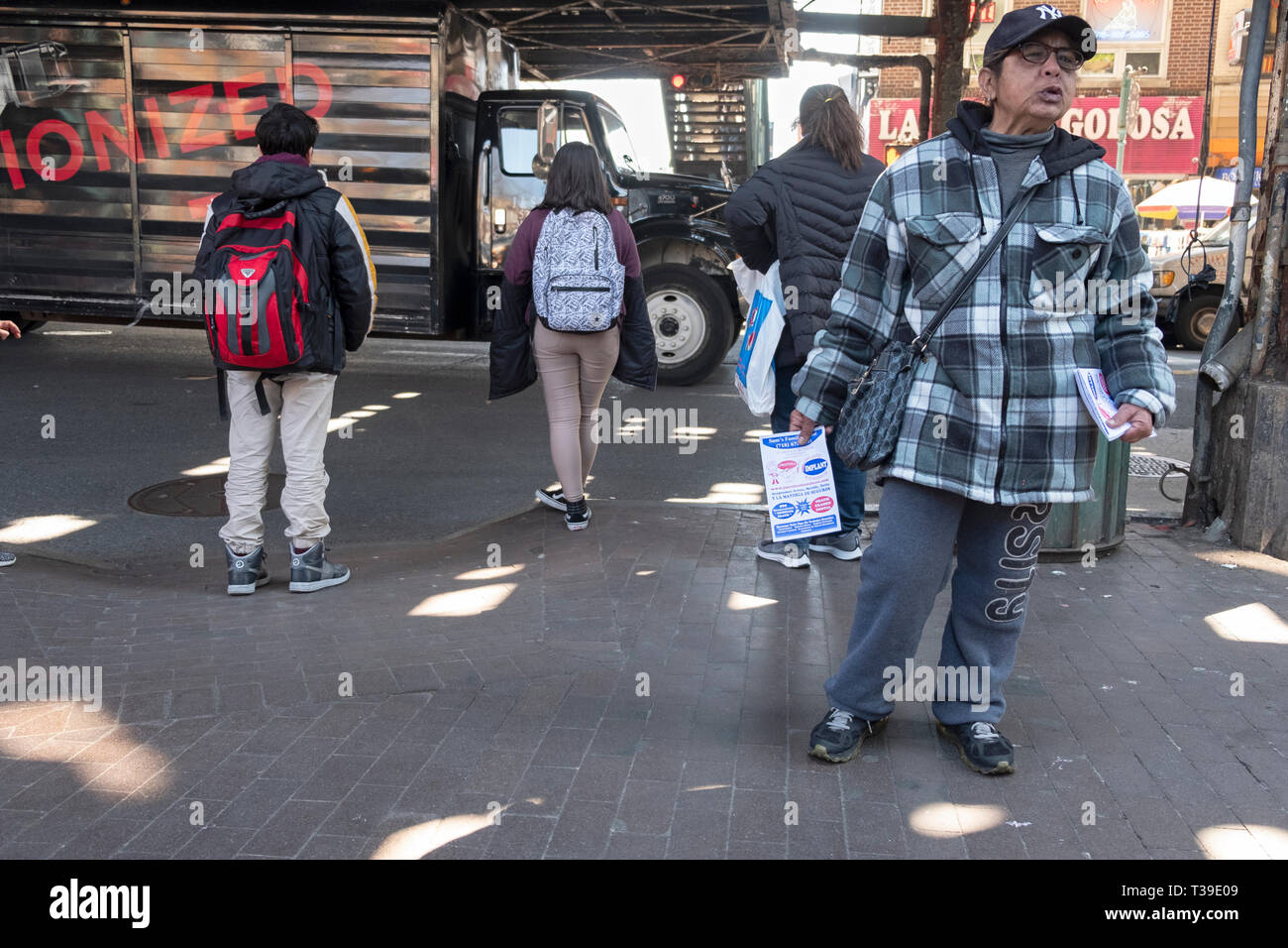 Un latino-americano di consegnare in spagnolo di volantini di pubblicità per un quartiere dentista. In corona, Queens, a New York City. Foto Stock