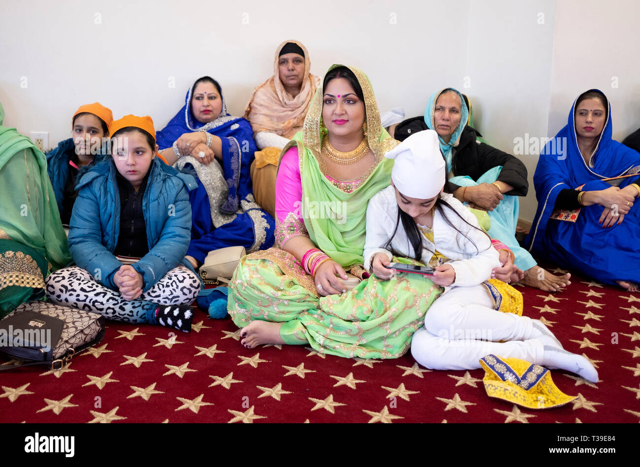 La religione sikh le donne e le figlie a servizi di mattina a un tempio in Richmond Hill, Queens, a New York City. Foto Stock