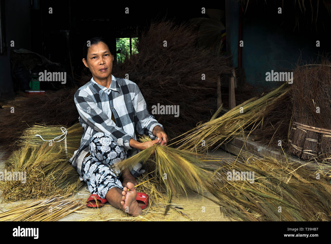 Donna vietnamita realizzare paglia scope in Duy Xuyen, Vietnam Foto Stock