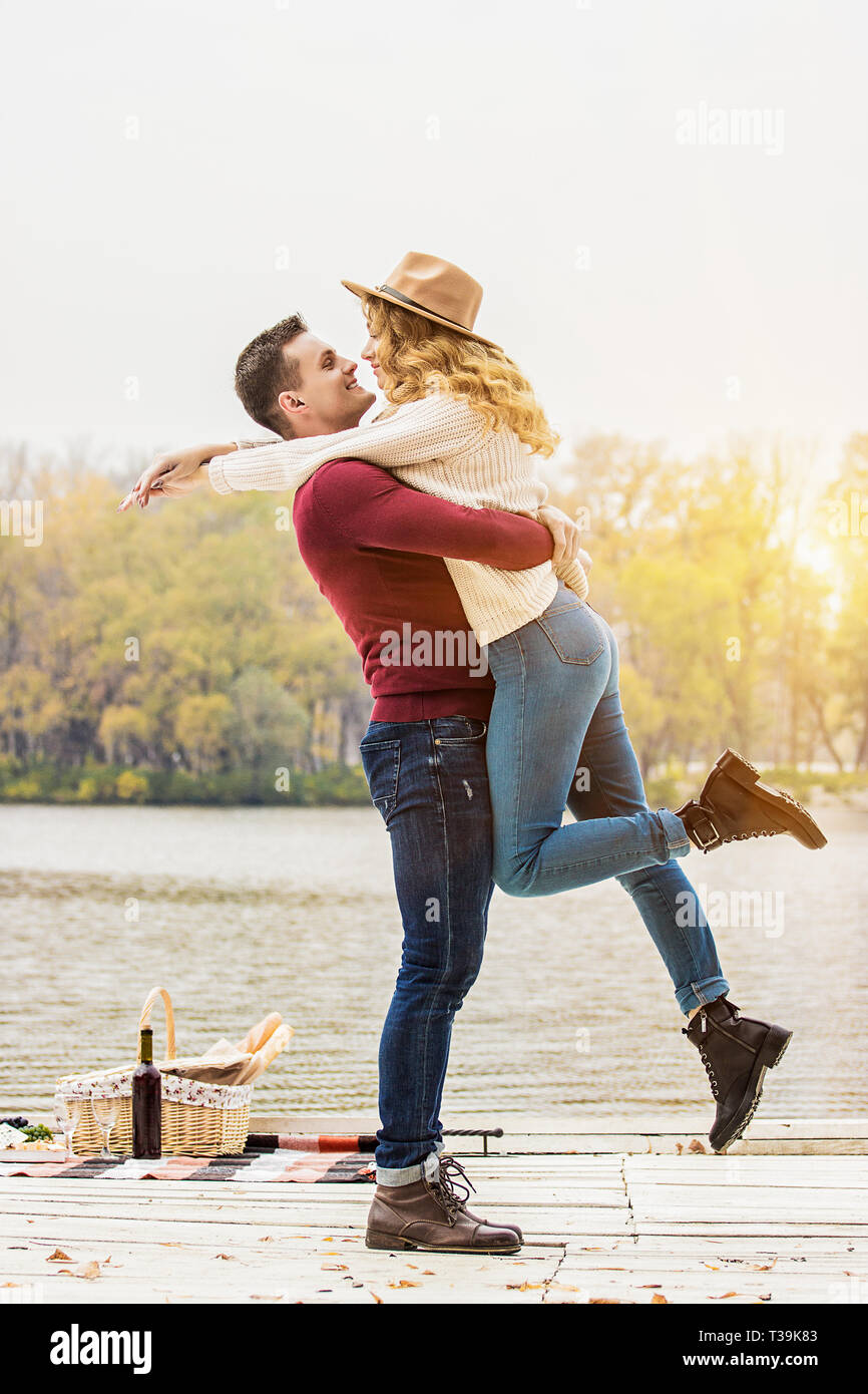 Sempre felici insieme. Colpo verticale del giovane uomo in abbigliamento casual portando la sua bella ragazza. Concetto di stare insieme. Coppia giovane nell'amore. Giovane Foto Stock