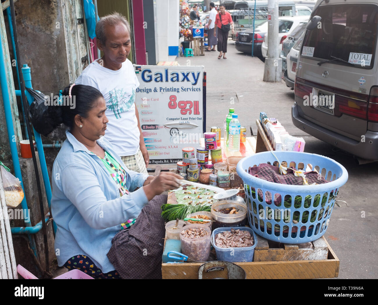 Venditore ambulante preparazione Paan (betel masticazione) per un cliente in attesa , un preparato combinando betel foglie con noci di arec dado e talvolta anche con tobac Foto Stock