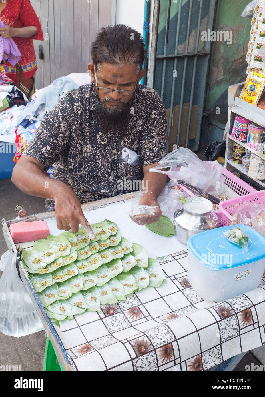Venditore ambulante preparazione Paan (betel masticazione) , una preparazione che unisce la foglia di betel con noci di arec dado e talvolta anche con il tabacco ampiamente consumati per montaggio passante Foto Stock