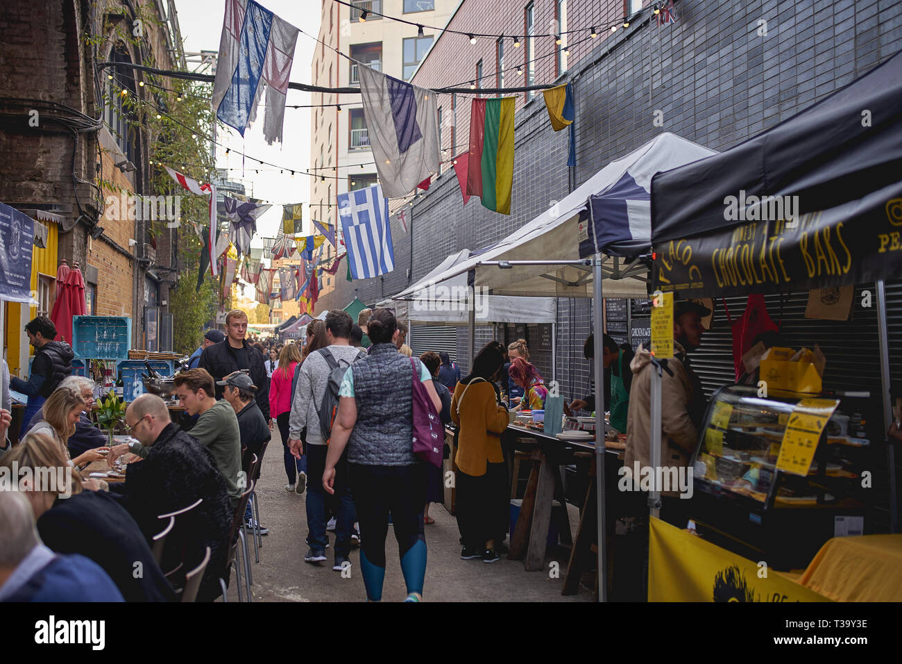 London, Regno Unito - Novembre, 2018. I giovani con bevande e cibo in Maltby Street Market, un gourmet street market alimentare tenutasi in Bermondsey. Foto Stock