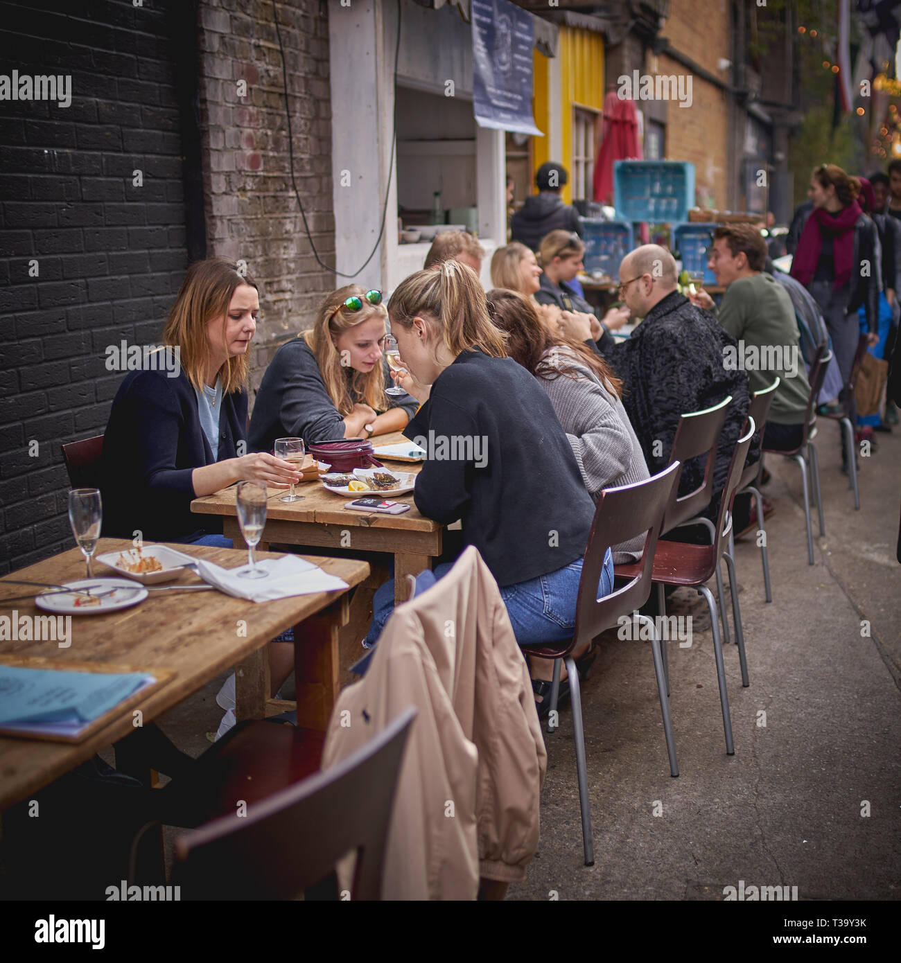 London, Regno Unito - Novembre, 2018. I giovani con bevande e cibo in Maltby Street Market, un gourmet street market alimentare tenutasi in Bermondsey. Foto Stock