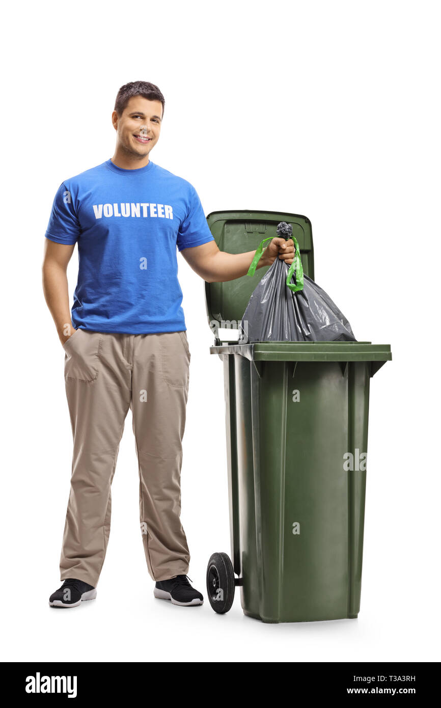 A piena lunghezza Ritratto di un giovane volontario gettare i rifiuti in un contenitore isolato su sfondo bianco Foto Stock
