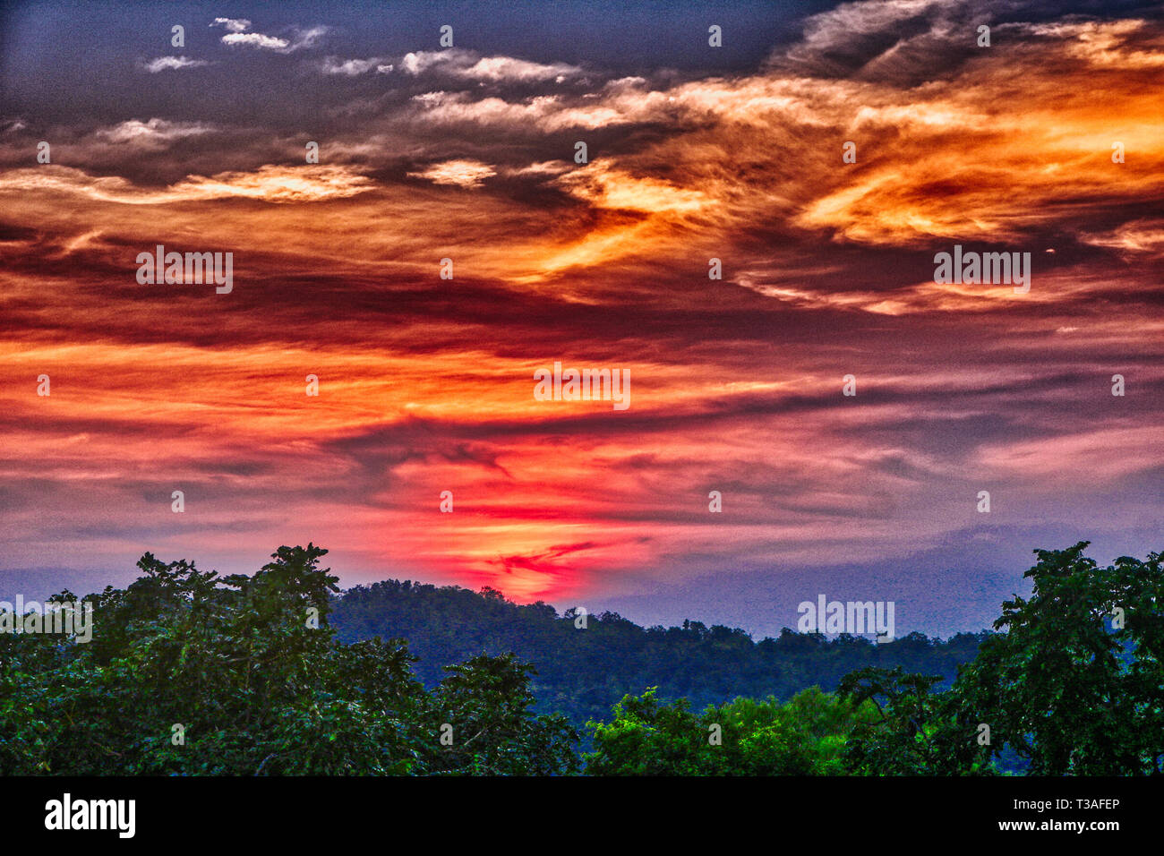 Questa unica immagine mostra il bellissimo tramonto rosso con grande nube formazione dietro le montagne in Hua Hin in Thailandia Foto Stock