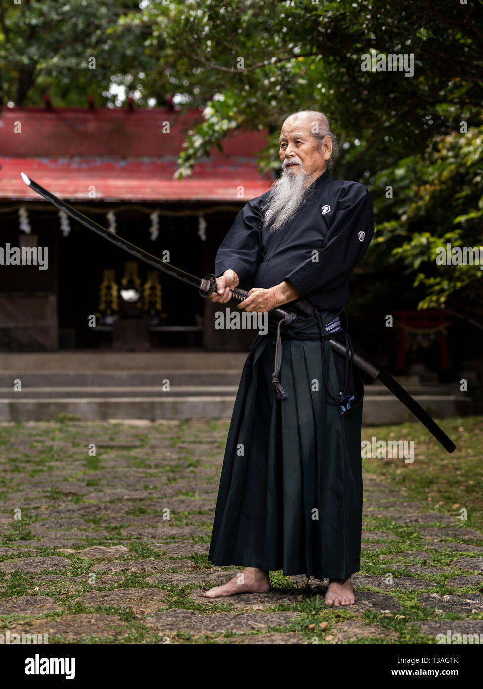 83-anno-vecchio Hisao Hamamoto, iaido master con la spada samurai di Okinawa in Giappone. Nome dello stile è Koden HachimanRyu Jissen BattoJutsu Hamamotoden BattoKai Foto Stock