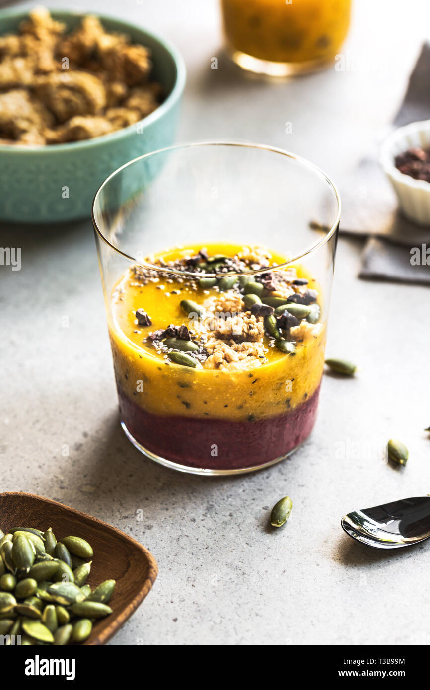 Mango,frutto della passione con mix Frullato di frutti di bosco con Chia,pennini di cacao e i semi di zucca topping Foto Stock