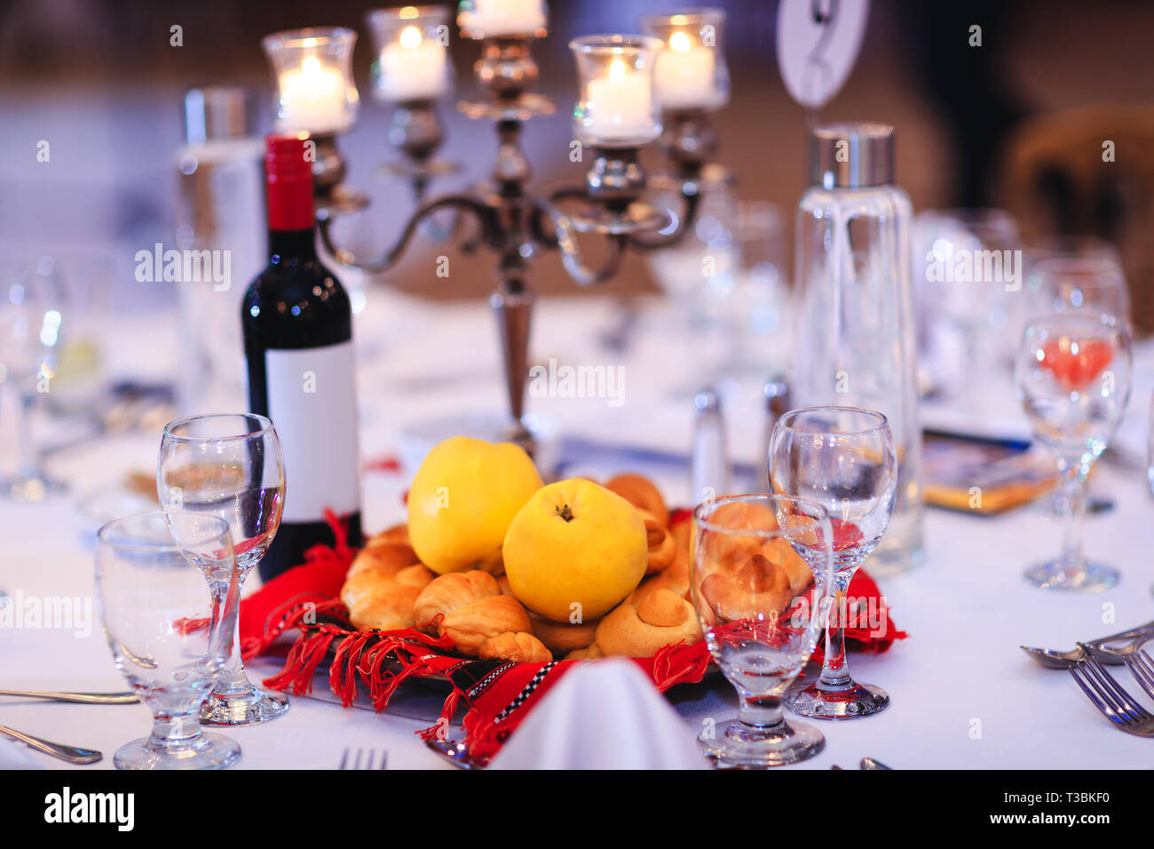 Tabella per banchetti con giallo cotogne, panini o focacce e una bottiglia di vino raccolte nel tradizionale Rumena asciugamano. Tabella vacanza decorate con tradizionale M Foto Stock