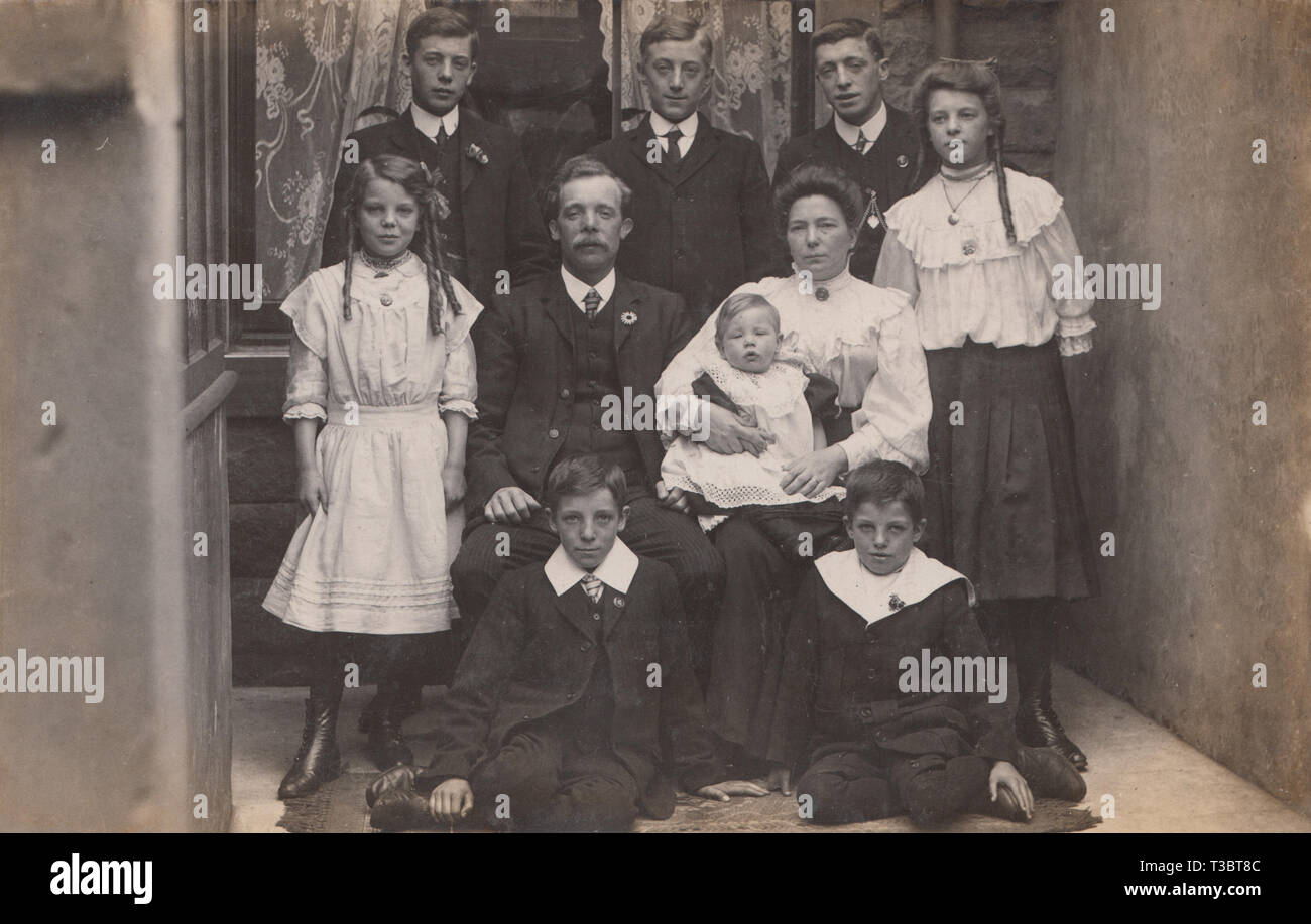 Vintage Cartolina fotografica che mostra un Edwardian famiglia, un padre ed una madre con i loro otto figli. Foto Stock