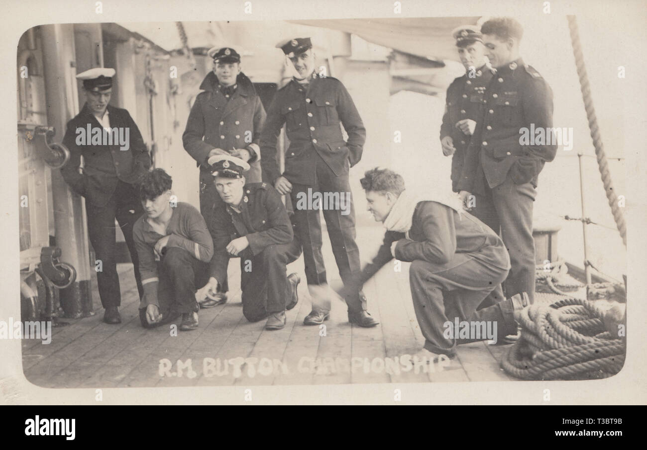 Vintage Cartolina fotografica che mostra un gruppo di British Royal Marines sul ponte di una nave la riproduzione dei Royal Marines Campionato del pulsante. Foto Stock