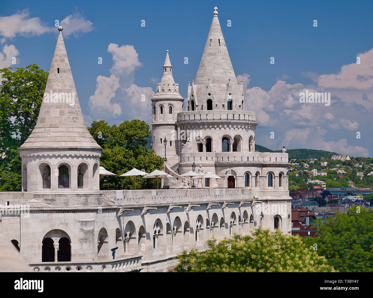 Ungheria, Budapest, Castle Hill, Fishermans Bastion, torri occidentale tra alberi e guardando verso l'estremità occidentale della città. Foto Stock