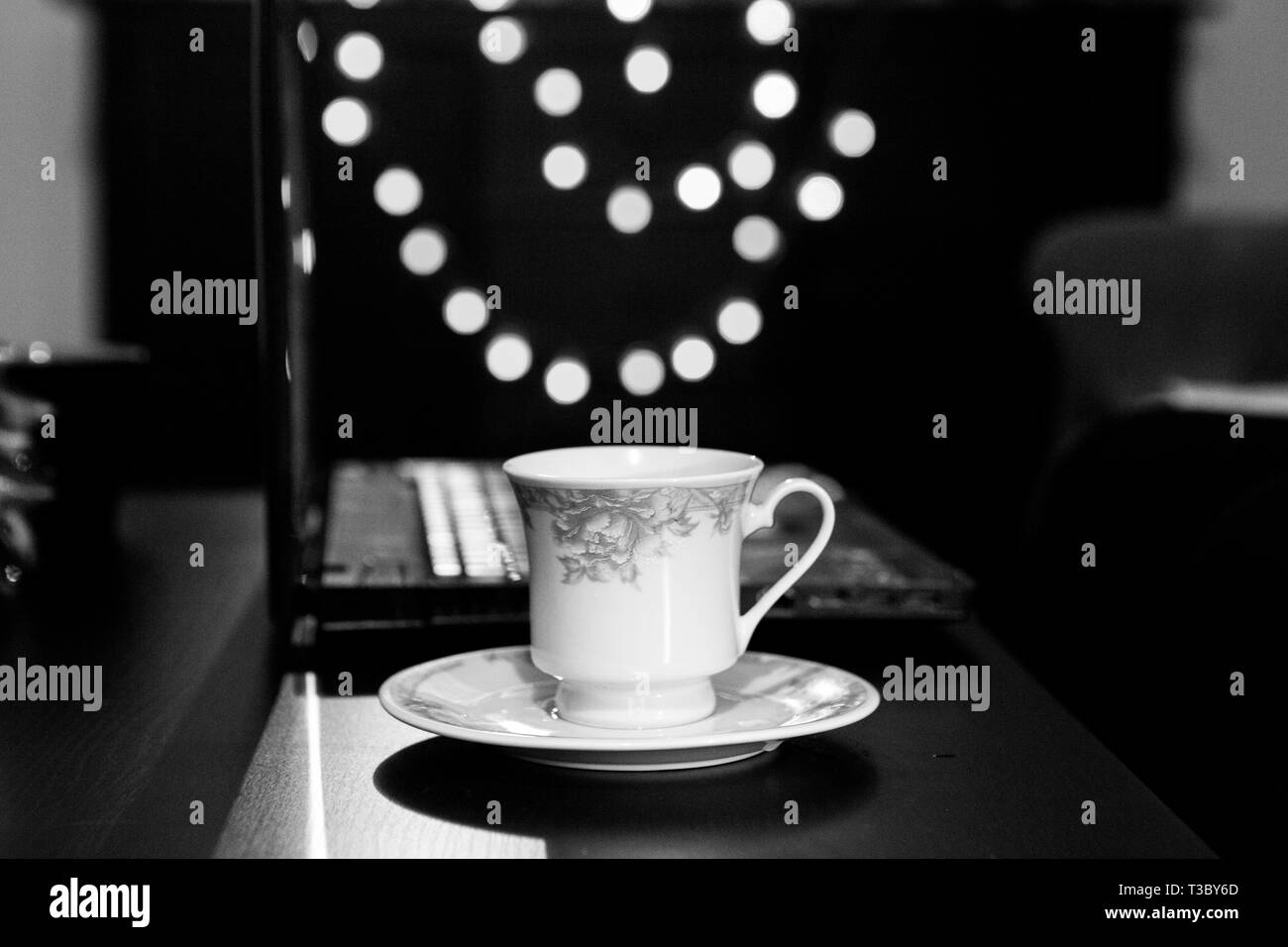 Bianco e Nero Tazza da caffè e il computer portatile in stile retrò Ambiente di lavoro Foto Stock