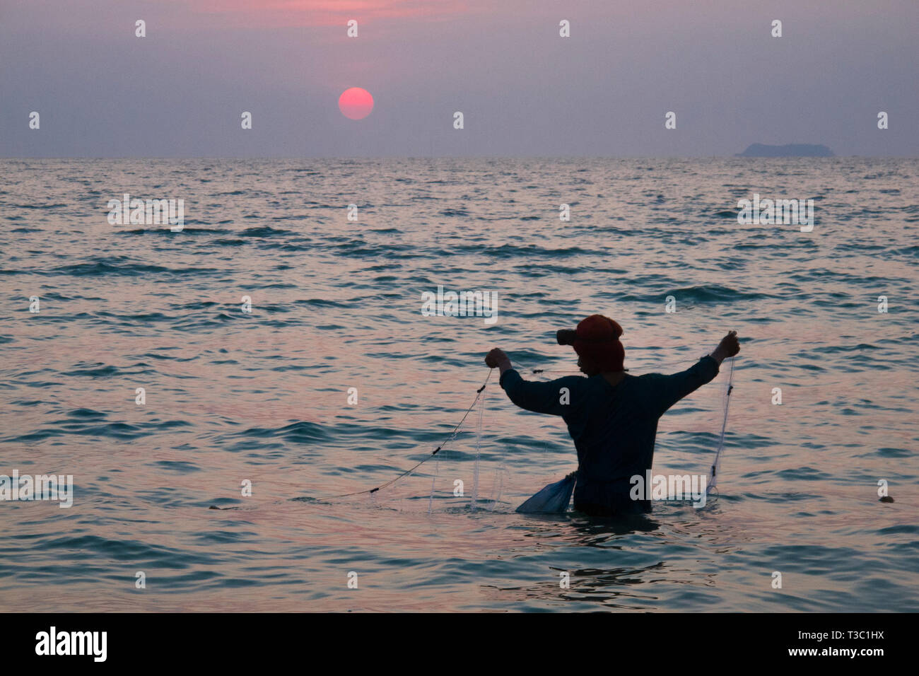 Un uomo è la pesca al tramonto, Koh Lanta, Thailandia. Foto Stock