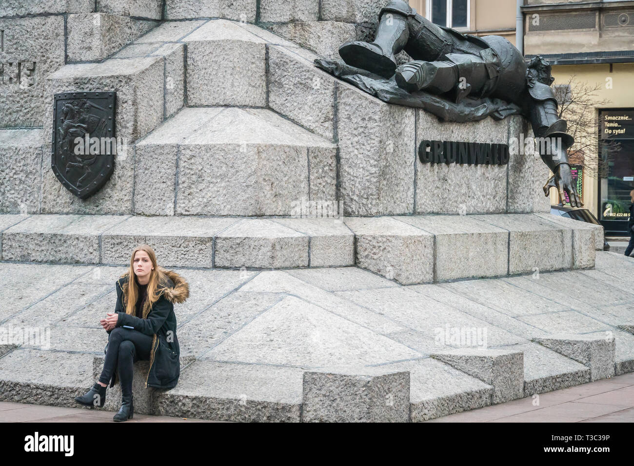 Cracovia in Polonia - Marzo 22, 2019 - una giovane ragazza si siede sul Grunwald monumento Foto Stock