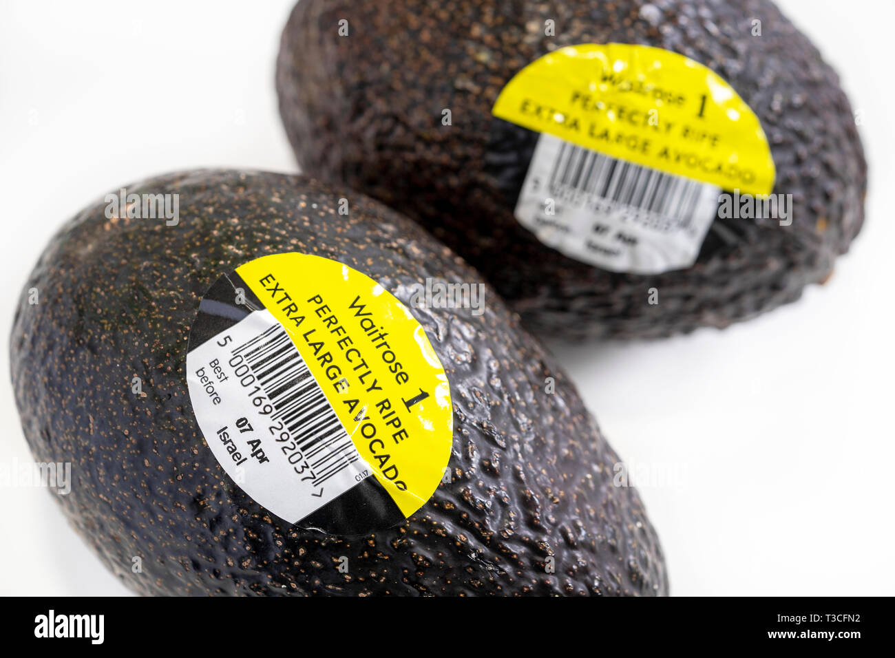 Codici a barre su etichette di avocado maturo su sfondo bianco Foto Stock