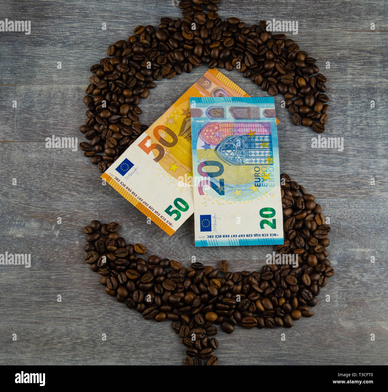 Commercio equo prezzo del caffè - caffè torrefatto in grani e denaro Foto Stock