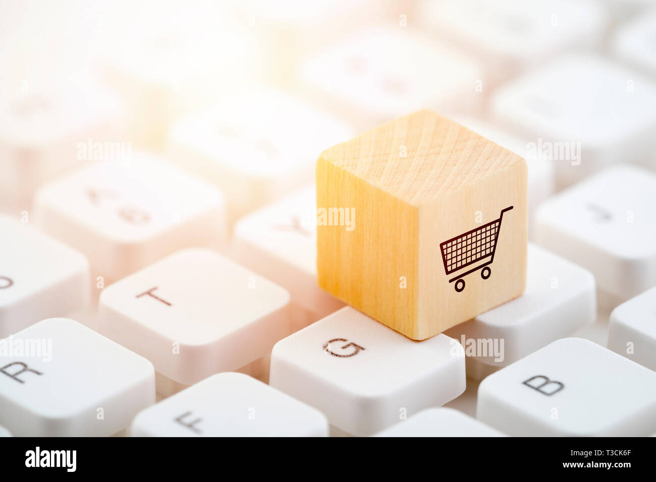Blocco di legno con carrello grafico sulla tastiera del computer. Shopping online concetto. Foto Stock