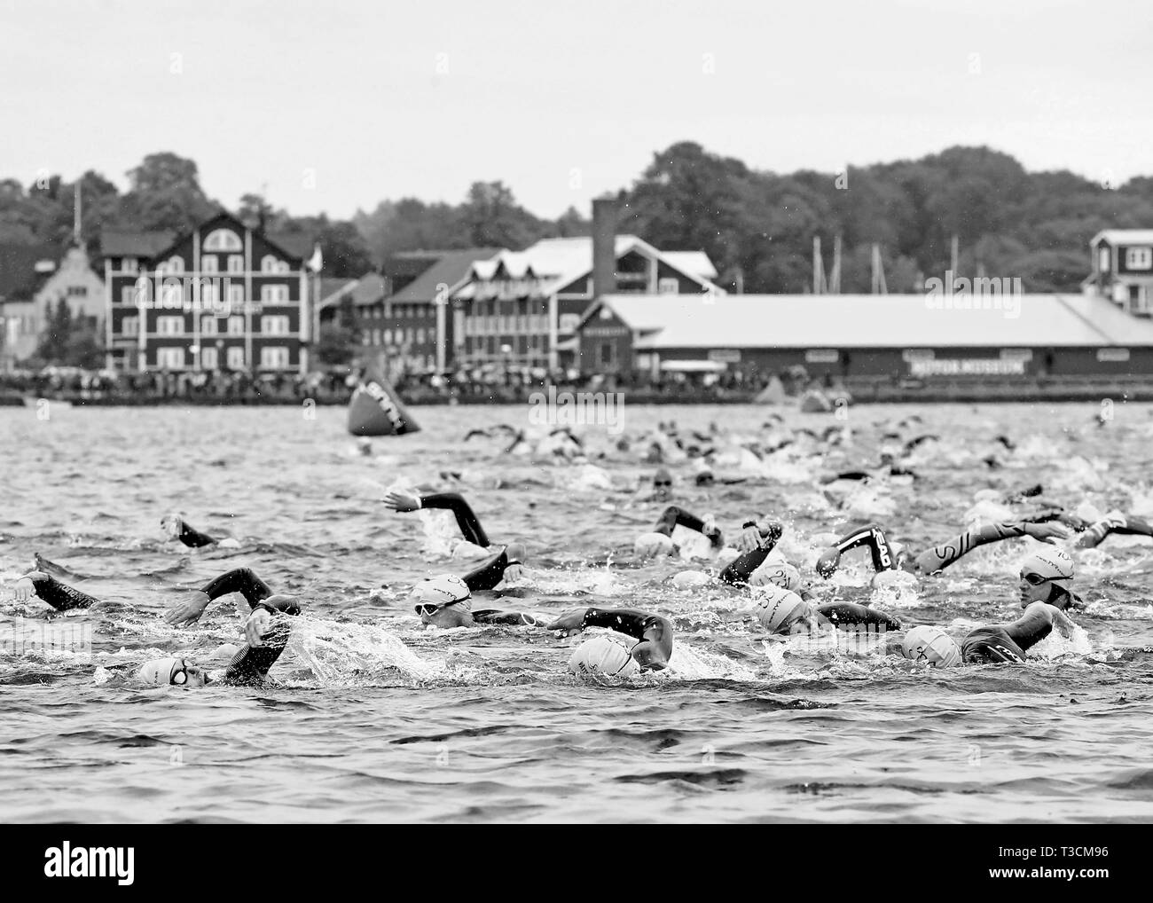 MOTALA 20140628 16 gradi nell'acqua di balneazione colorati i cappucci e una memorabile udienza. "Vätterntriathlon' è in esecuzione. Immagine: Triatleti sulla strada in su dal lago Vättern, Motala ponte in background. Foto Jeppe Gustafsson Foto Stock