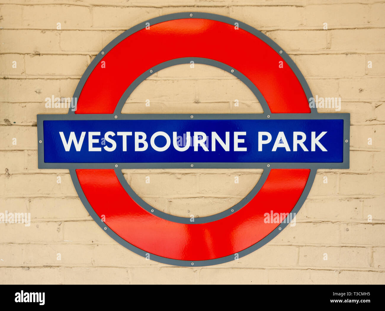 La metropolitana di Londra emblema recante il nome della stazione sulla parete a Westbourne Park stazione della metropolitana di Londra. Foto Stock