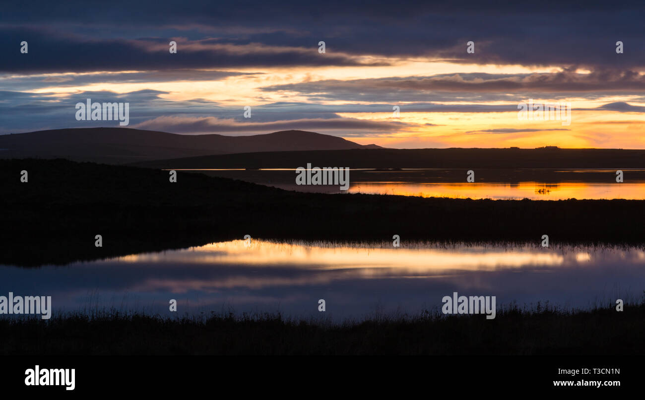 Crepuscolo vista attraverso i loch di Harray verso Hoy, Orkney Islands. Foto Stock