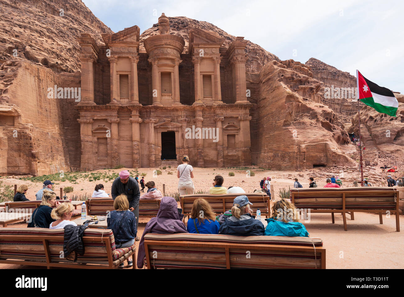 I turisti in cafe ammirare la vista del monastero Ad-Deir di Petra in Giordania.Sito Patrimonio Mondiale dell'UNESCO Foto Stock