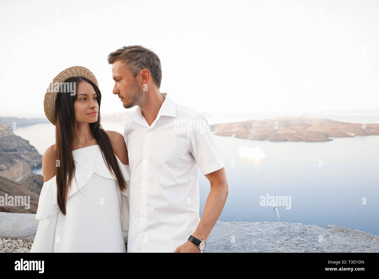 Stile di vita all aperto foto di felice coppia giovane in bianco città europea. Camminando sulla isola di Santorini Foto Stock