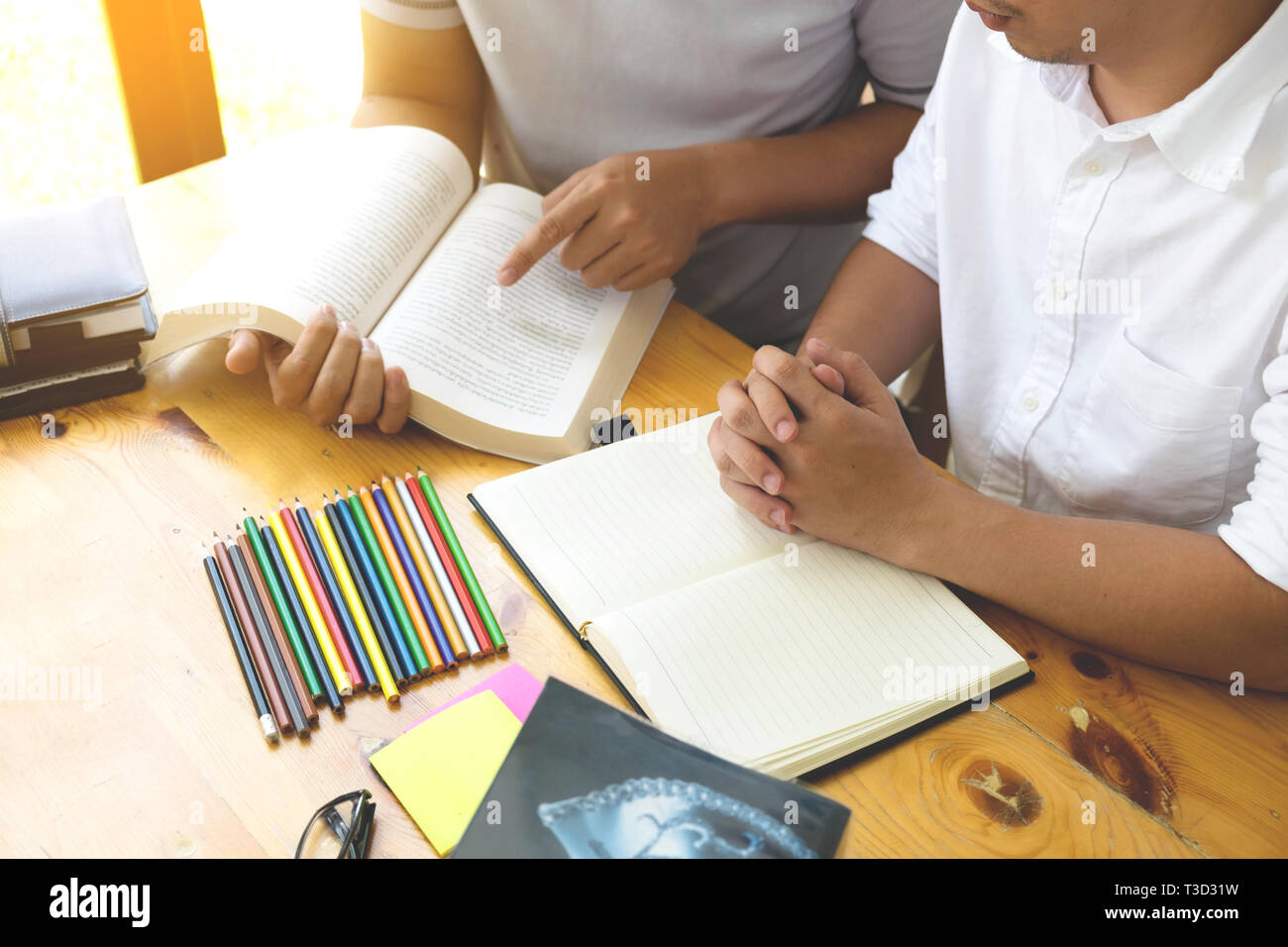 Gli studenti amico aiuta l insegnamento e l apprendimento oggetto ulteriori nella libreria. Il concetto di istruzione. Foto Stock