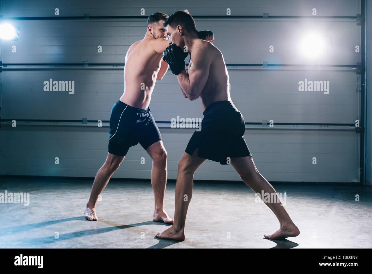 Forte shirtless a piedi nudi sportivi mma lotta mentre l uomo punzonatura di un altro Foto Stock