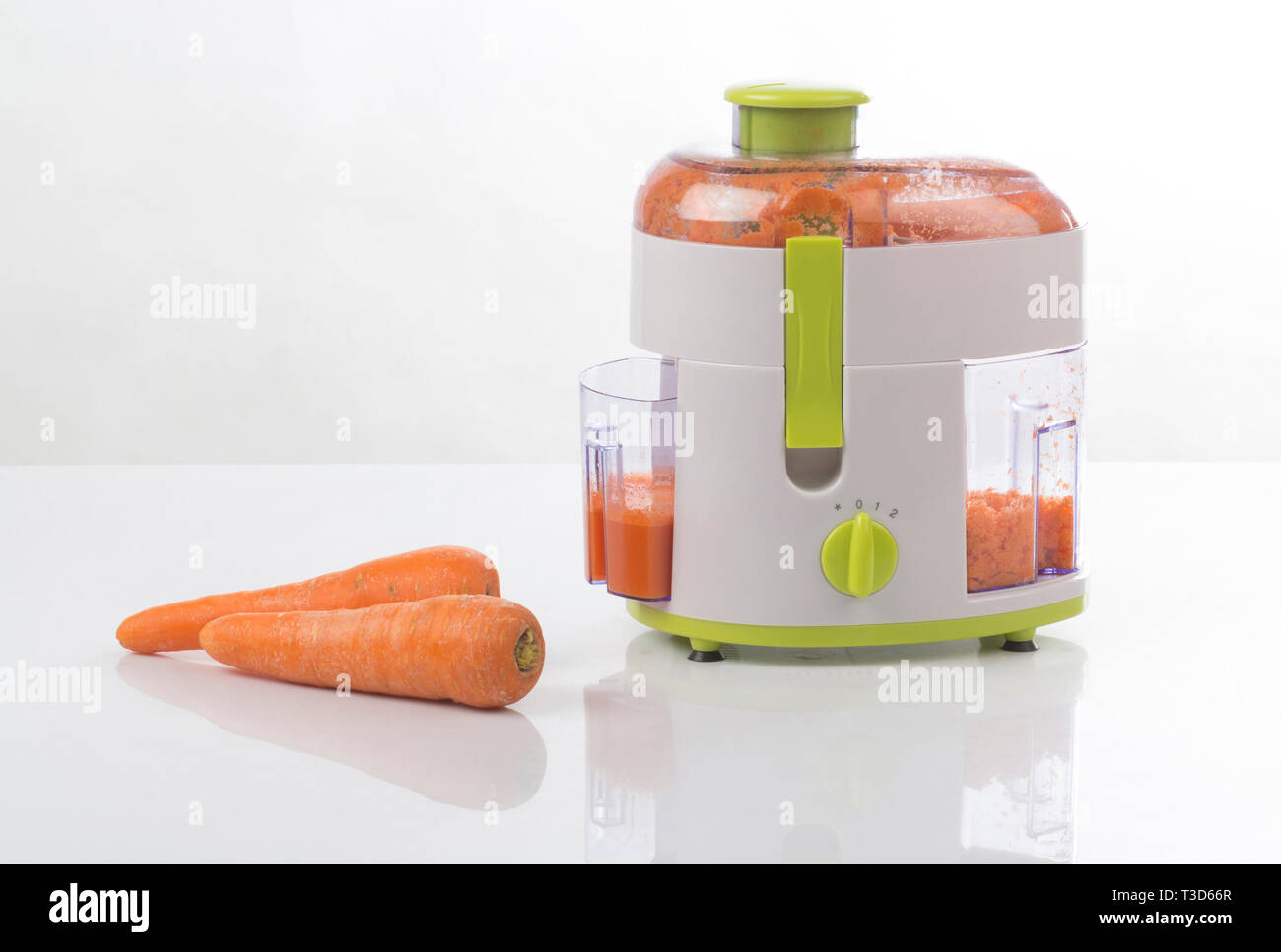 Risidue e separatore in fibra macchina con succo di carota all'interno isolato su sfondo bianco Foto Stock