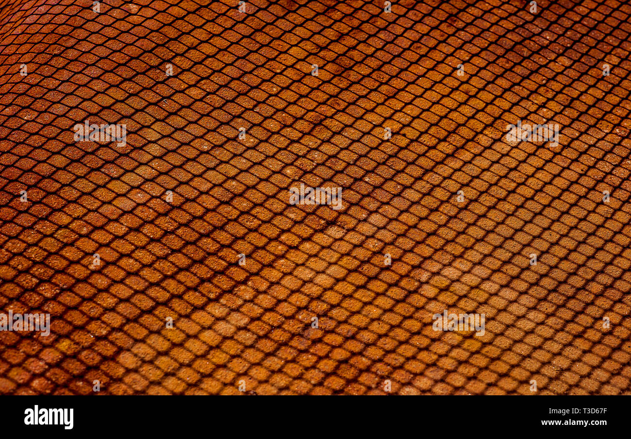 Shedow intessute di rete di filo di ferro arrugginito sul foglio di lamiera. Superficie con profondità di campo industriale astratta vecchia maglia sfondo orizzontale Foto Stock