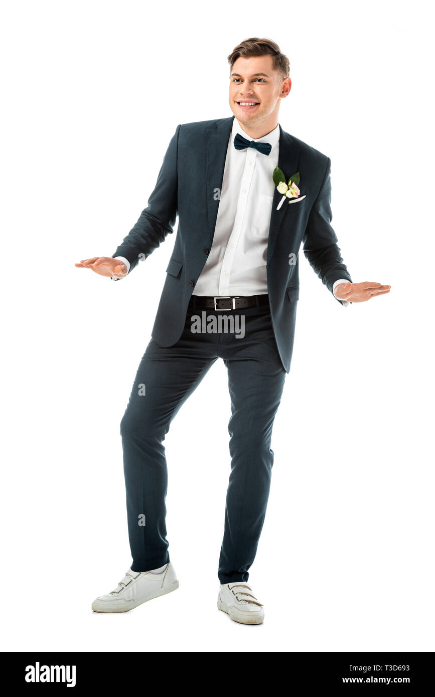 Felice giovane sposo dancing in nero elegante abito bianco e sneakers  isolato su bianco Foto stock - Alamy