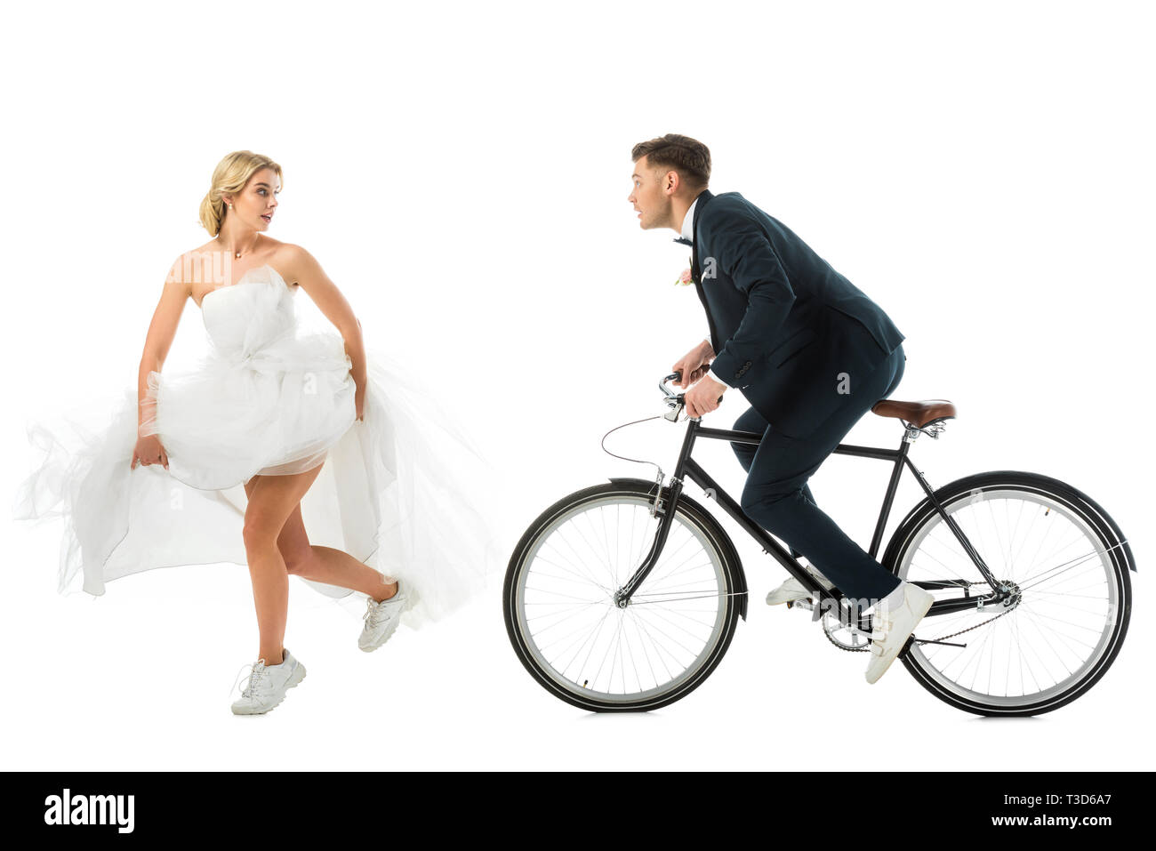 Attraente sposa in abito da sposa e scarpe da ginnastica in esecuzione da  sposo sulla bicicletta isolato su bianco Foto stock - Alamy