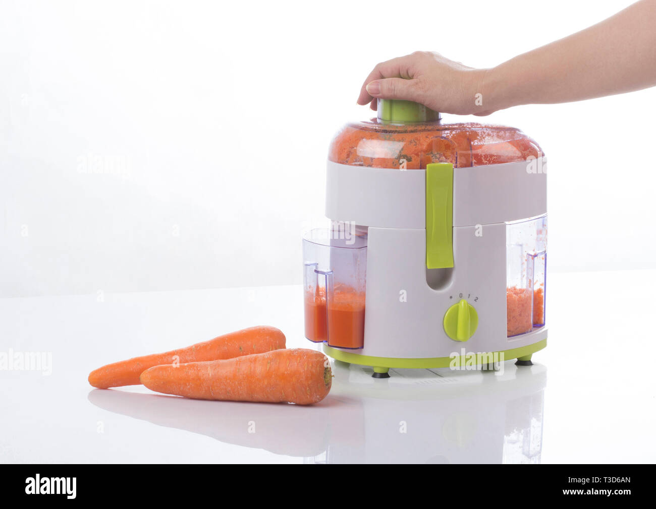 Residuo e separatore in fibra macchina con succo di carota interno su sfondo bianco Foto Stock