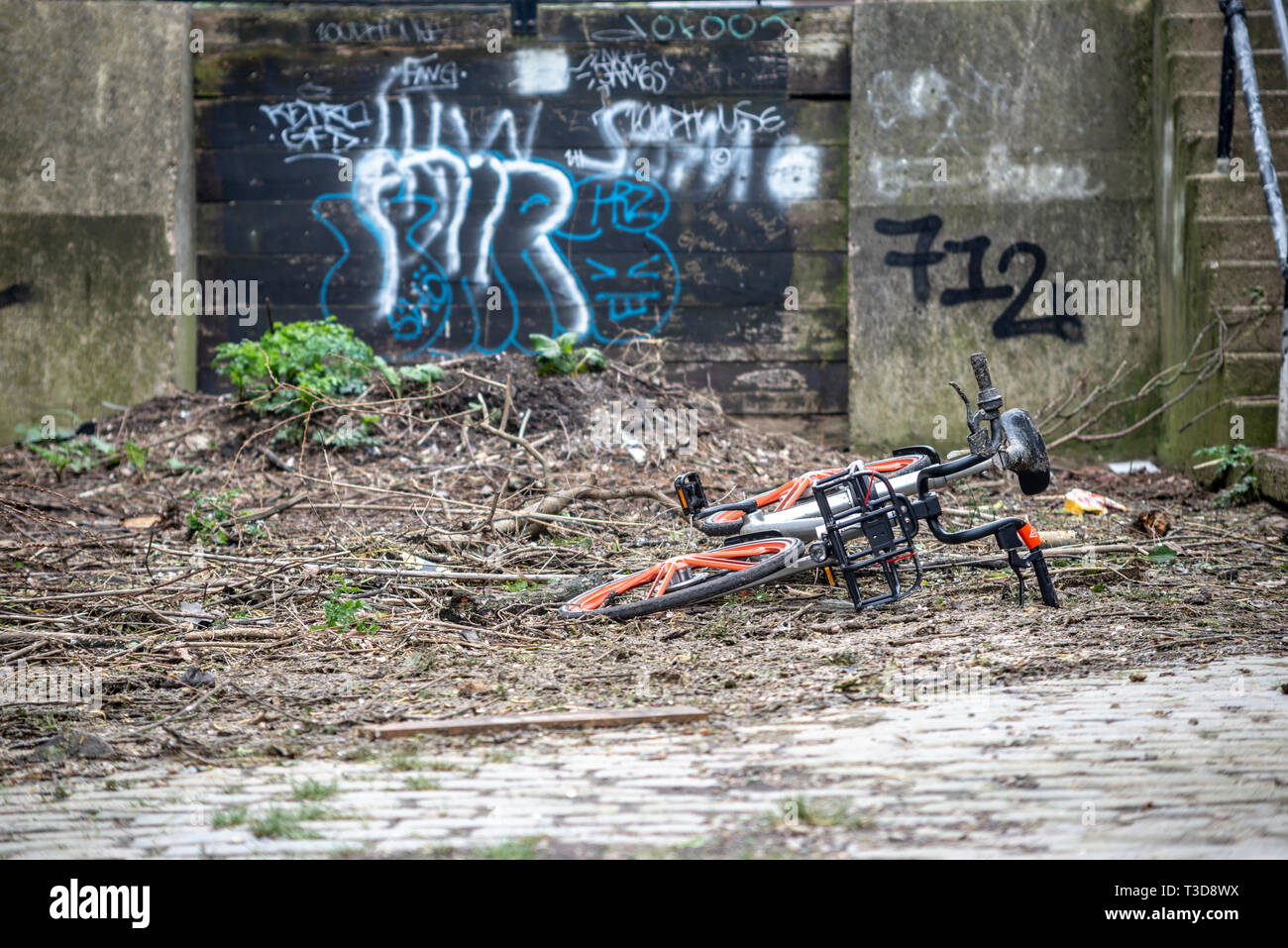 Alta Marea rami, di detriti e spazzatura lavato fino contro una difesa flood barrier gate presso Barnes includente un dumping regime noleggio bicicletta, London, Regno Unito Foto Stock