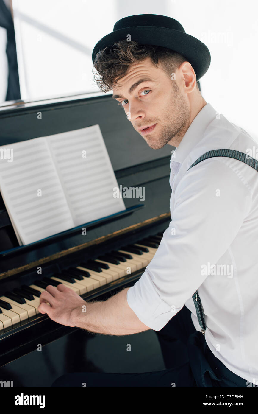 Bello il pianista in abbigliamento elegante suonare il pianoforte a casa  Foto stock - Alamy