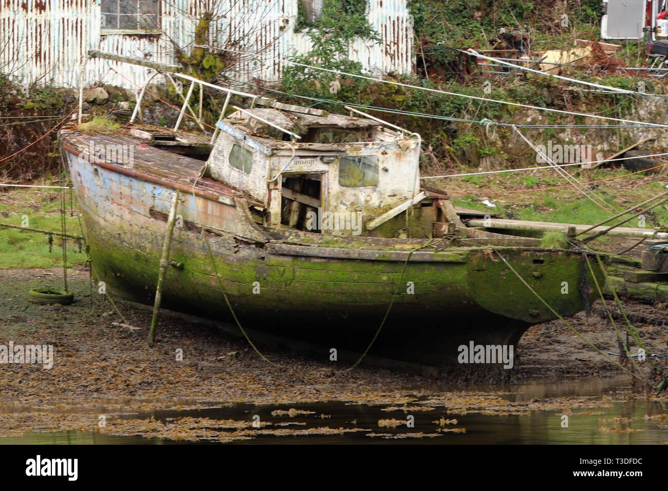 Barca abbandonata sulla riva del fiume Foto Stock