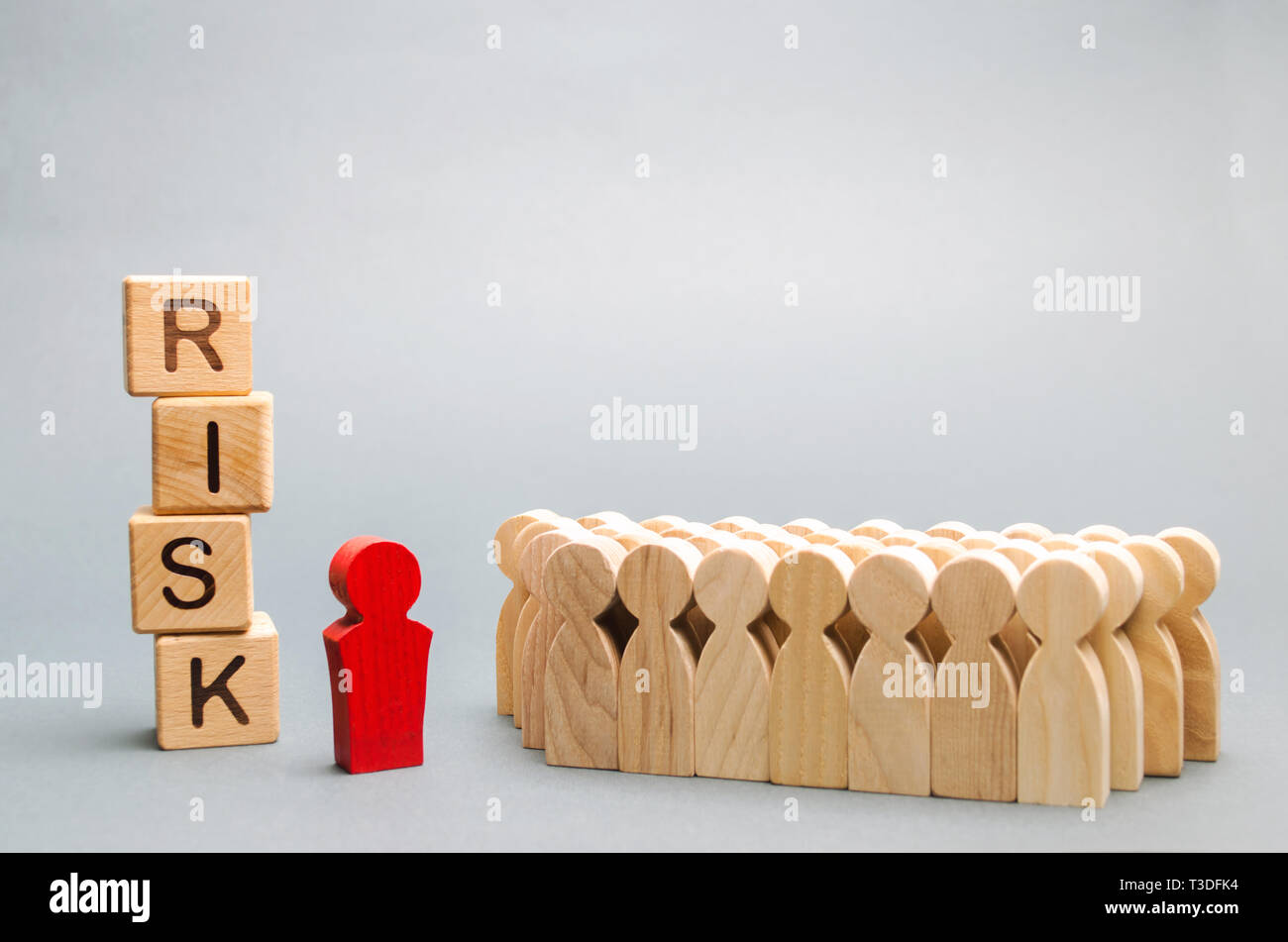 Blocchi di legno con la parola rischio e un team con un leader. Il concetto di business di un lavoro di squadra, la soluzione delle crisi e la gestione dei problemi. La pianificazione delle attività di business. In Foto Stock