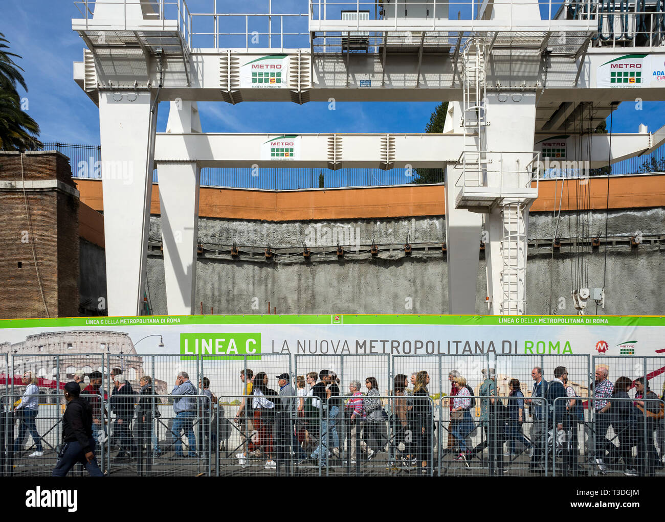 Colosseo, Roma, Italia 04/06/2019: nuova linea metropolitana c edificio, Fori Imperiali stazione. In close-up persone che passeggiano, sito in costruzione di gru in t Foto Stock