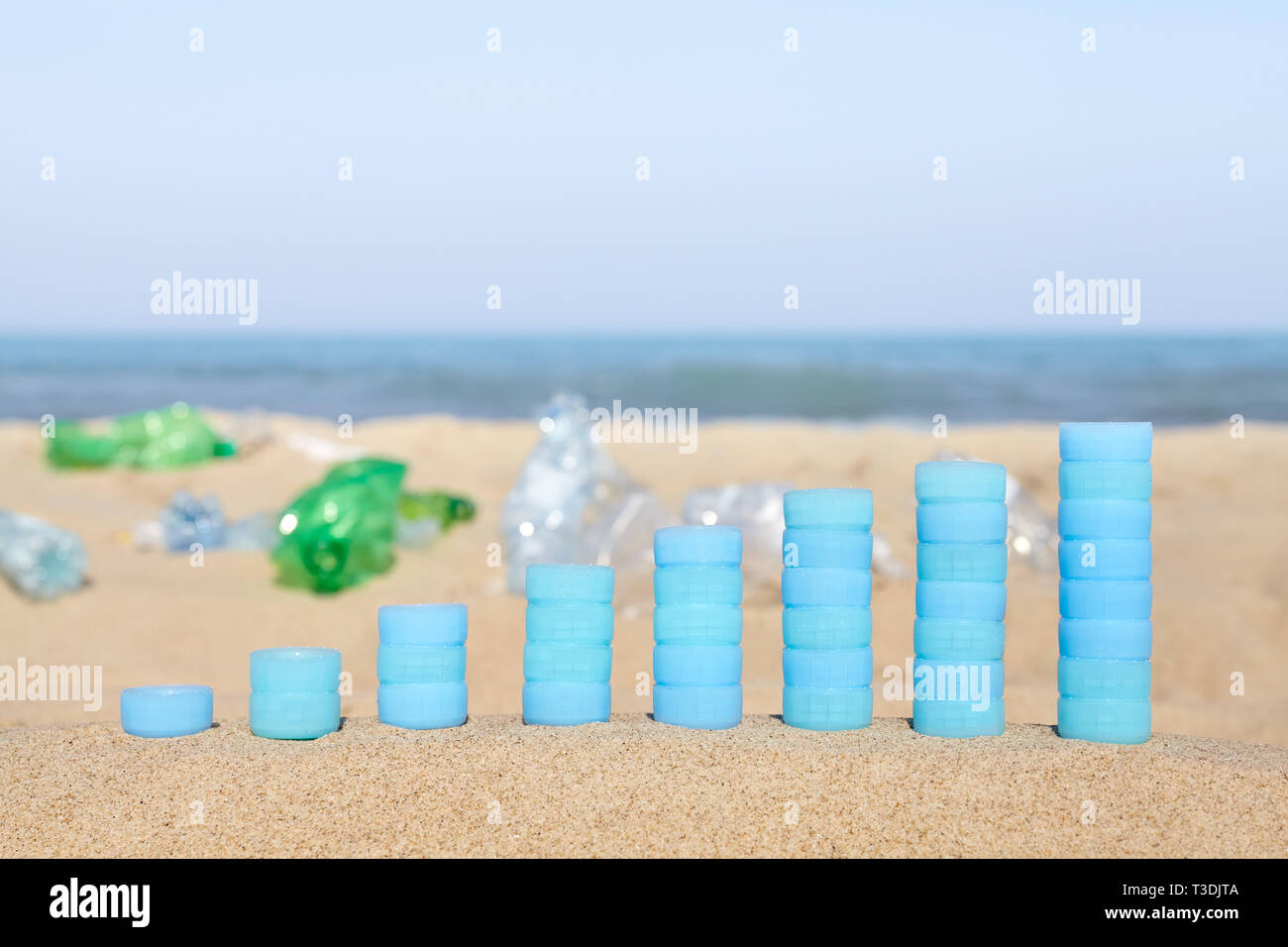 Grafico fatta di bottiglie di plastica tappi su sabbia che mostra l'aumento di uso singola i prodotti in plastica trovati sulle spiagge europee. Foto Stock
