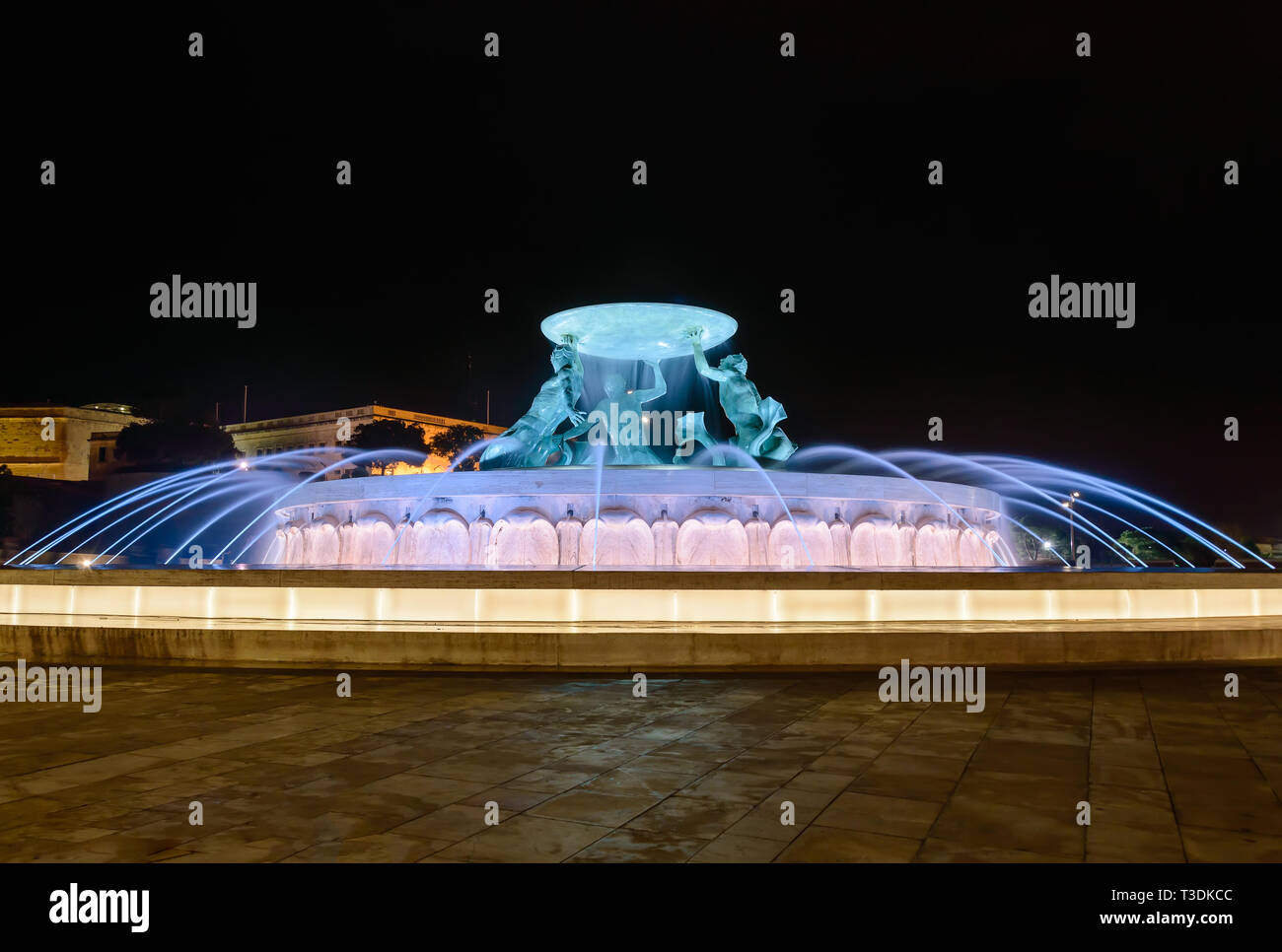 Fontana del Tritone a La Valletta, Malta con acqua corrente e colorata illuminazione notturna Foto Stock