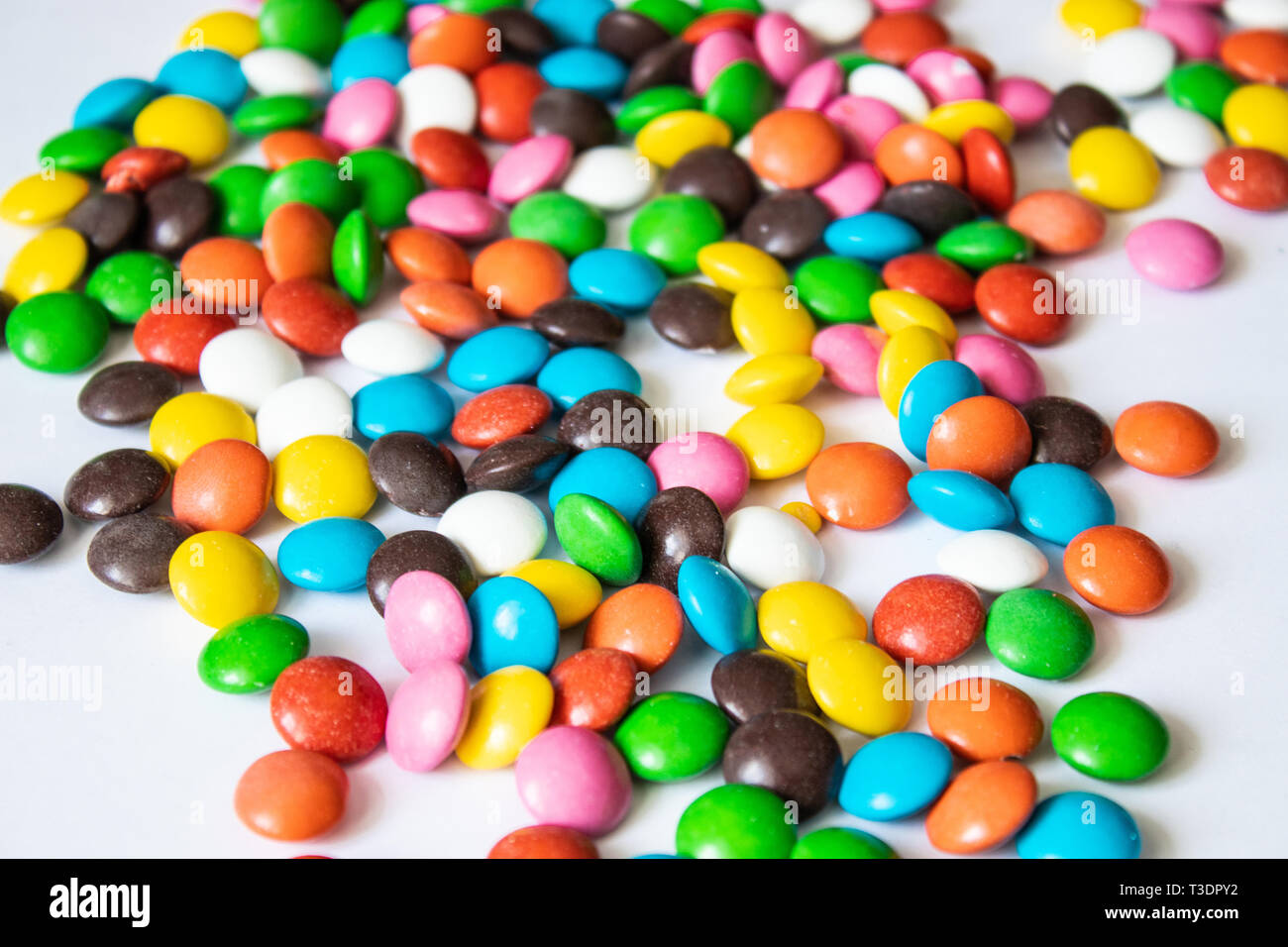 Round, multi-caramelle colorate. Candy closeup su uno sfondo bianco. Un mucchio di caramelle multicolore Foto Stock